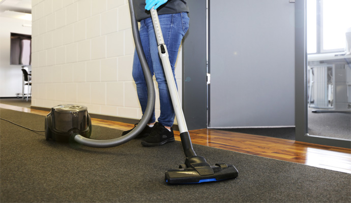 a man cleaning carpet using vacuum cleaner