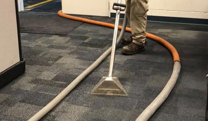 A professional cleaning a commercial carpet