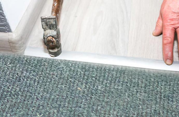 Repairing carpet tack strips with hammer 